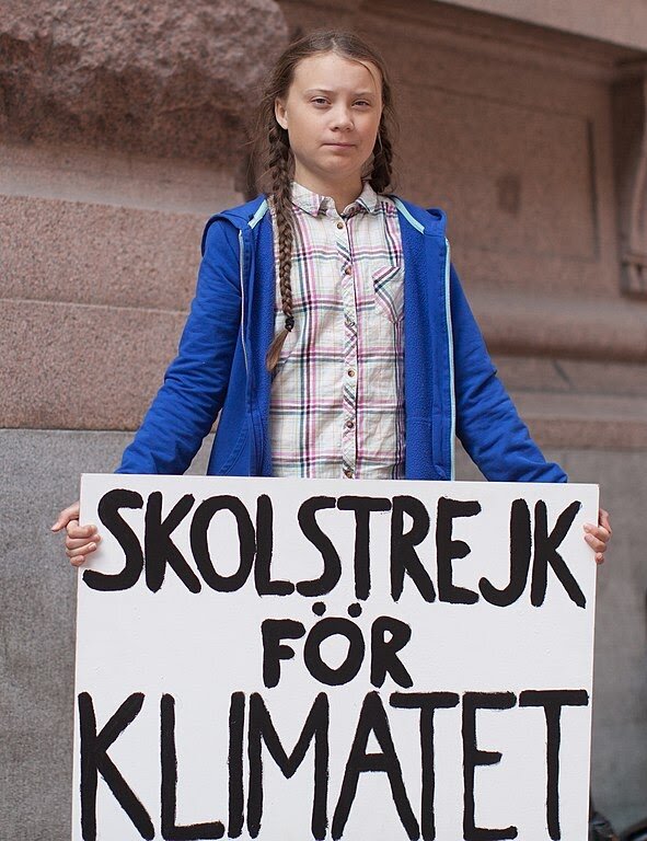 Image by Anders Hellberg via Wikimedia.In August 2018, outside the Swedish parliament building, Greta Thunberg started a school strike for the climate. Her sign reads, “Skolstrejk för klimatet,” meaning, “school strike for climate”.